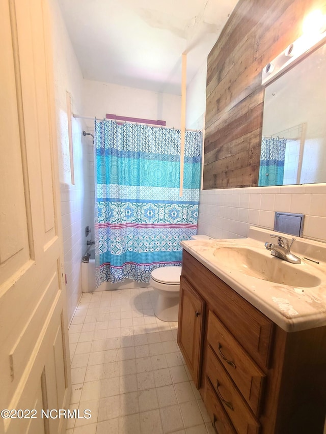 full bathroom with toilet, vanity, tile walls, backsplash, and tile flooring