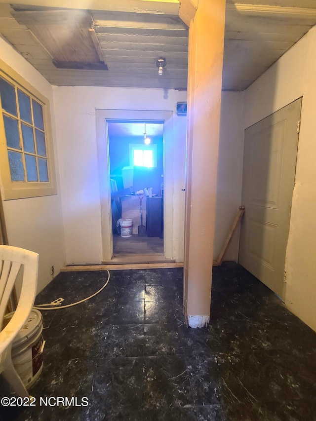 hallway featuring dark tile flooring