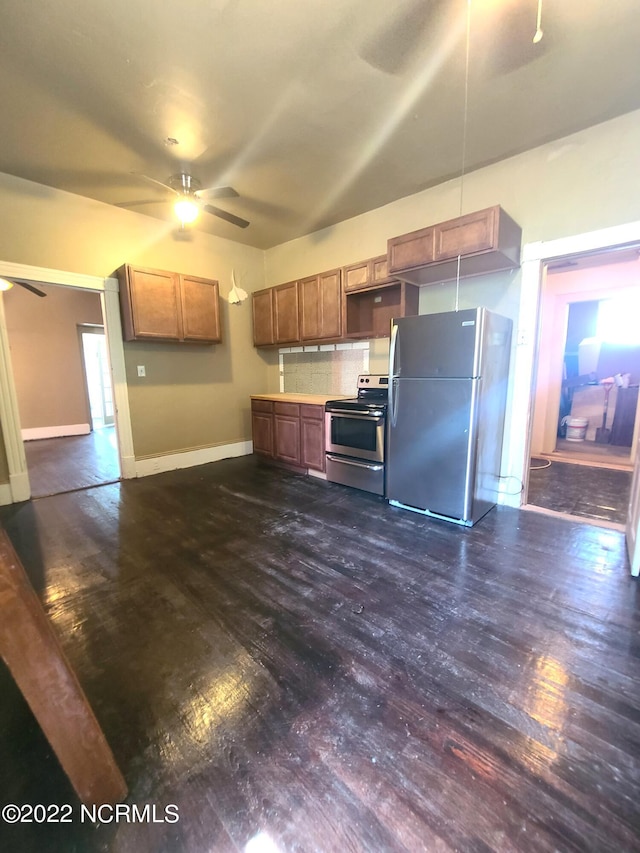 kitchen featuring backsplash, ceiling fan, appliances with stainless steel finishes, and dark wood-type flooring