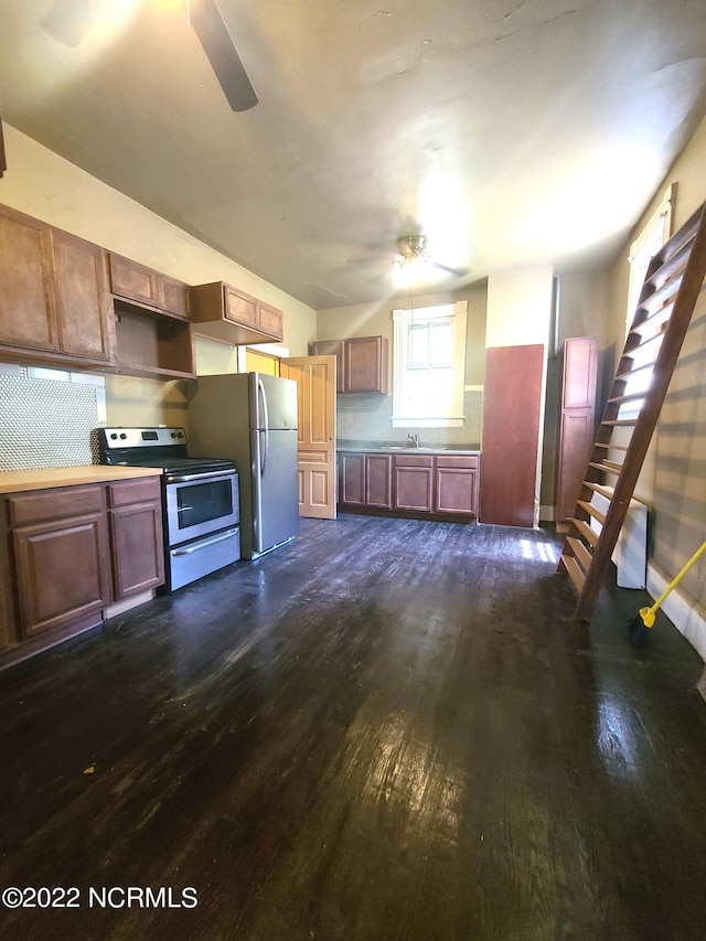 kitchen with appliances with stainless steel finishes, ceiling fan, sink, and dark hardwood / wood-style flooring