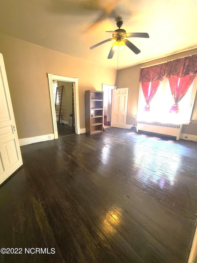 interior space featuring radiator, ceiling fan, and dark hardwood / wood-style flooring