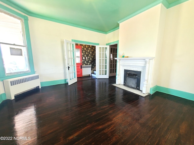 unfurnished living room with french doors, dark hardwood / wood-style flooring, ornamental molding, and radiator heating unit