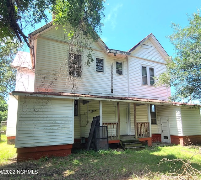 view of front facade featuring covered porch and a front yard