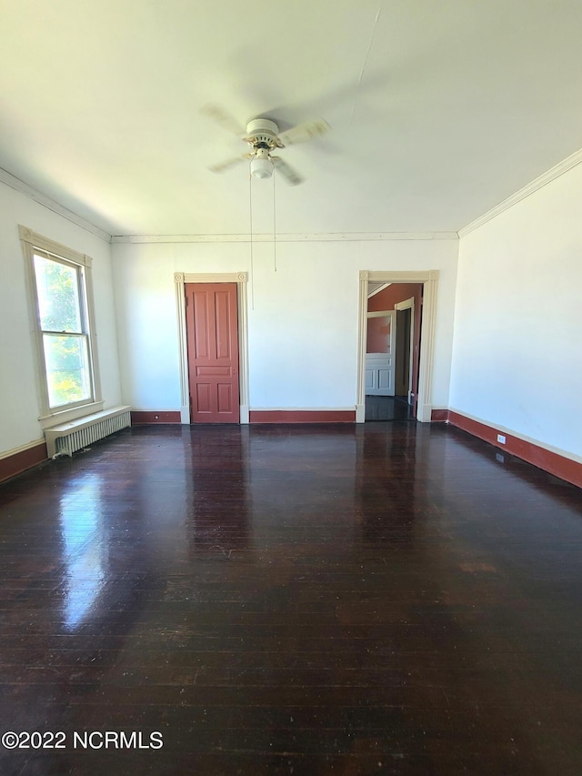 unfurnished room featuring crown molding, dark hardwood / wood-style flooring, ceiling fan, and radiator