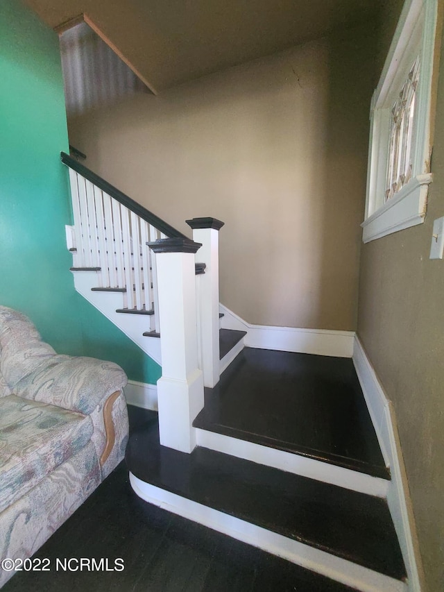 stairway with dark hardwood / wood-style flooring