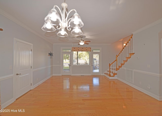 foyer entrance with stairway, baseboards, crown molding, ceiling fan with notable chandelier, and light wood-type flooring