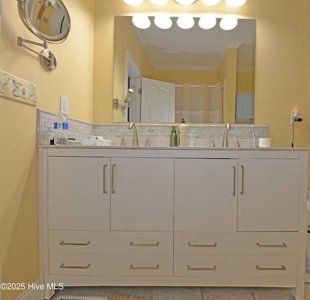 full bathroom with a sink, tasteful backsplash, ornamental molding, and double vanity