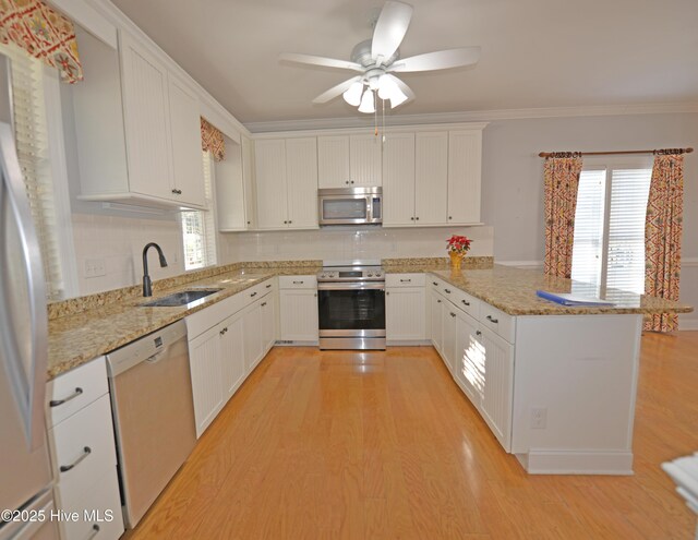 kitchen with white cabinetry, a breakfast bar area, light hardwood / wood-style floors, kitchen peninsula, and stainless steel appliances