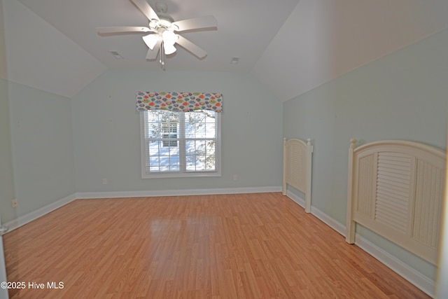 unfurnished room featuring baseboards, light wood-style flooring, a ceiling fan, and lofted ceiling