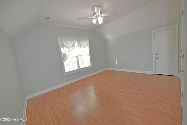 unfurnished room with baseboards, light wood-style floors, a ceiling fan, and vaulted ceiling