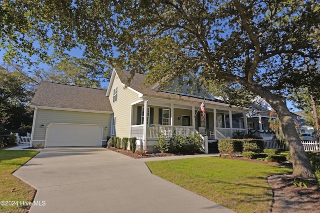 view of front of home featuring a front yard, fence, driveway, an attached garage, and covered porch