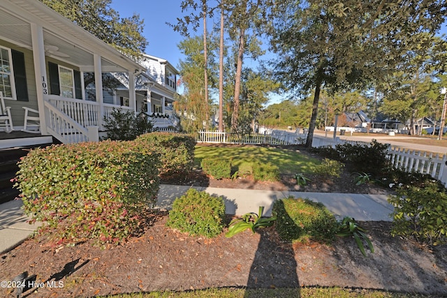 view of yard featuring covered porch and fence