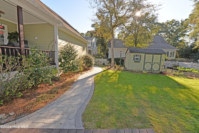 view of yard with fence, an outbuilding, and a shed