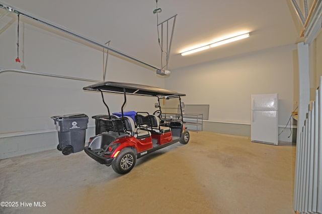 garage featuring a garage door opener and freestanding refrigerator