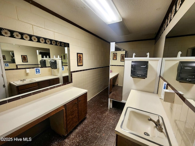 bathroom featuring sink, tile walls, and a textured ceiling