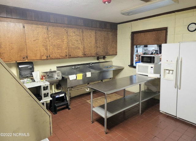 kitchen featuring white appliances and dark tile patterned floors