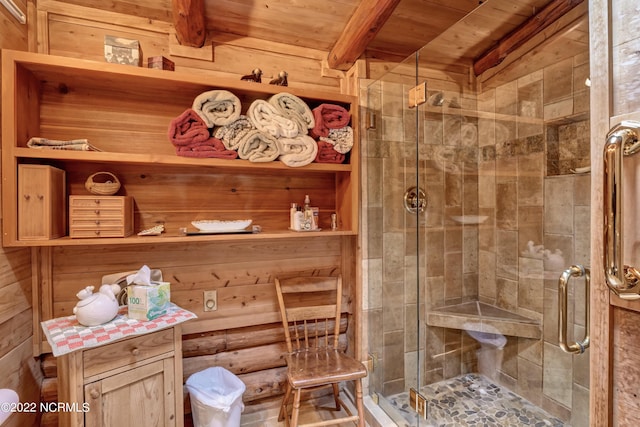 bathroom featuring wood walls, wood ceiling, a shower with shower door, and beamed ceiling