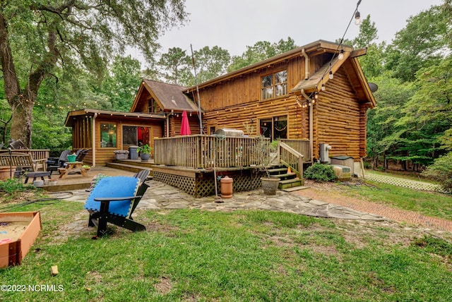 back of property with a yard and a wooden deck