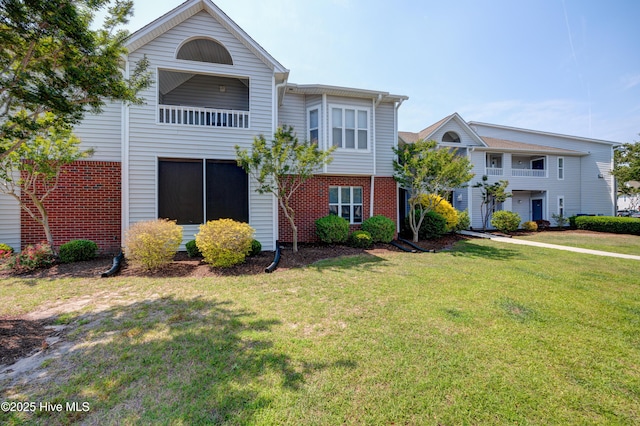 view of front of property featuring brick siding and a front yard