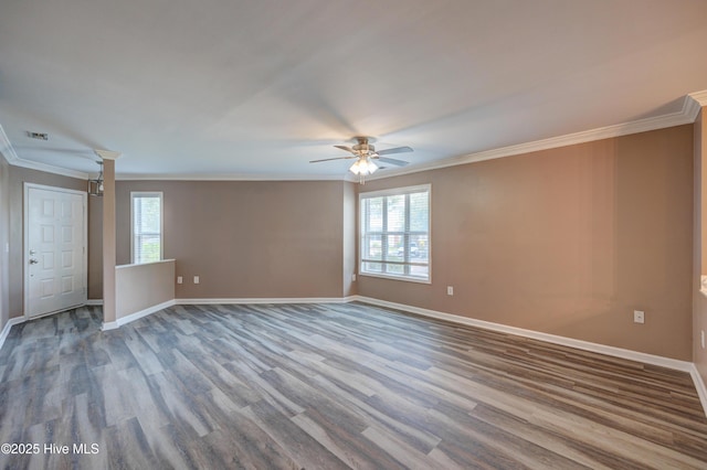 spare room with ceiling fan, wood finished floors, crown molding, and baseboards