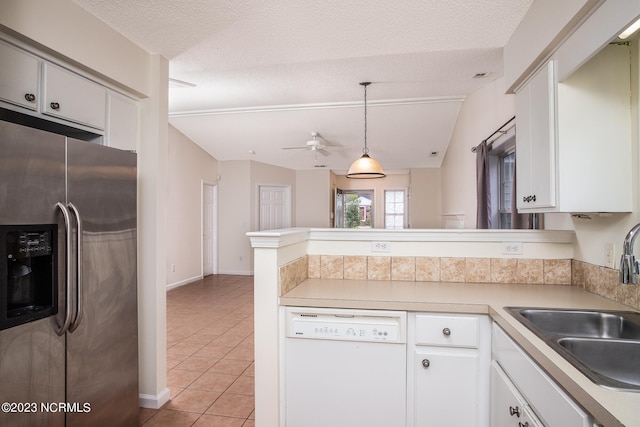 kitchen with white dishwasher, lofted ceiling, ceiling fan, white cabinetry, and stainless steel fridge