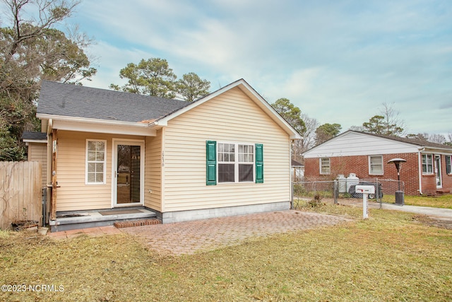 view of front of house with a front yard and central AC