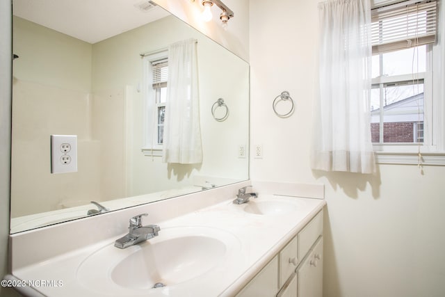 bathroom with plenty of natural light, oversized vanity, and dual sinks