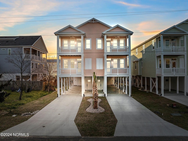 view of front of property featuring a front lawn, a carport, and concrete driveway