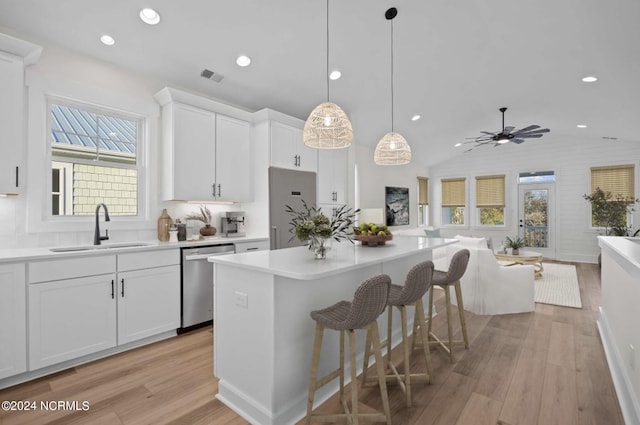 kitchen featuring visible vents, light wood-style floors, open floor plan, a sink, and dishwasher