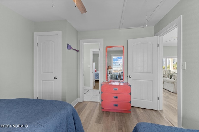 bedroom featuring multiple windows, ensuite bathroom, light wood-type flooring, and ceiling fan