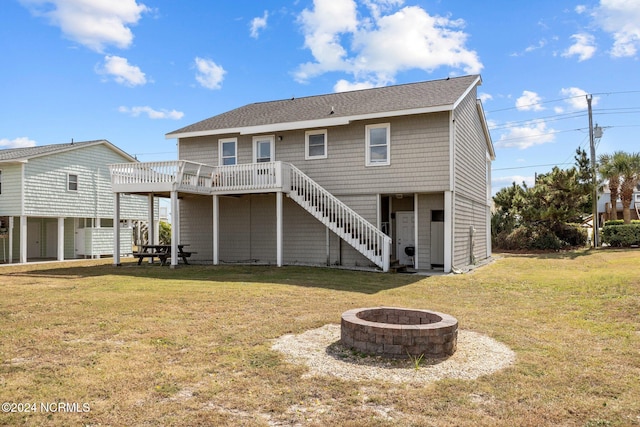 back of house with a yard, a deck, and a fire pit