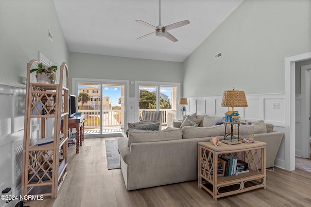 living room featuring light hardwood / wood-style floors, high vaulted ceiling, and ceiling fan