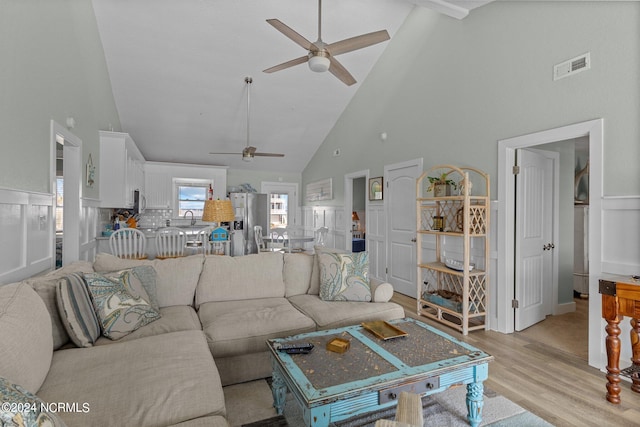 living room with high vaulted ceiling, sink, light wood-type flooring, and ceiling fan