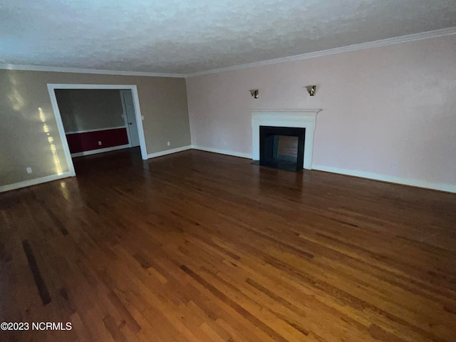 unfurnished room with a textured ceiling, crown molding, and dark wood-type flooring