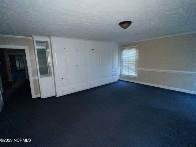 carpeted empty room with a textured ceiling