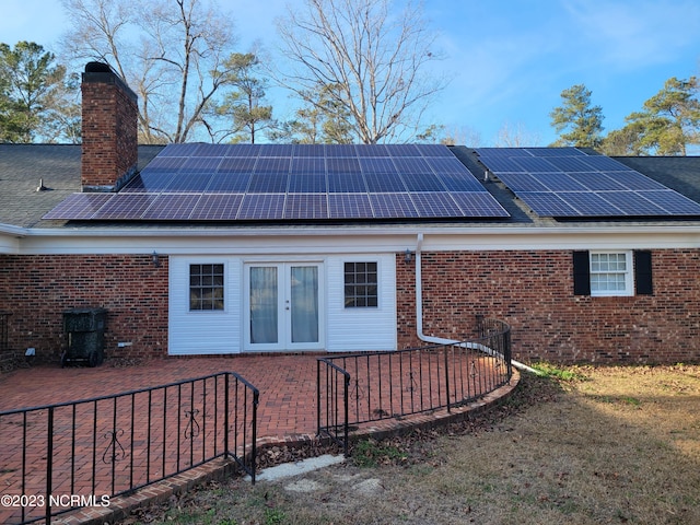 back of property featuring solar panels and french doors