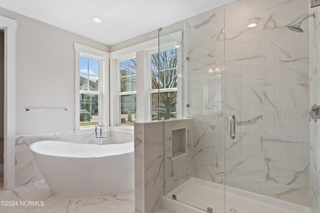 bathroom featuring plus walk in shower and tile walls