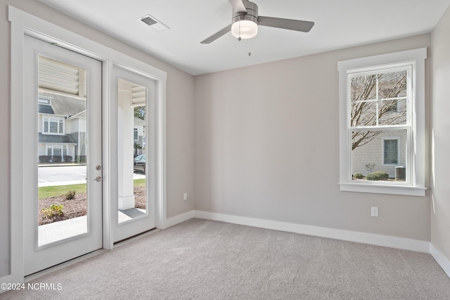 spare room featuring light colored carpet and ceiling fan