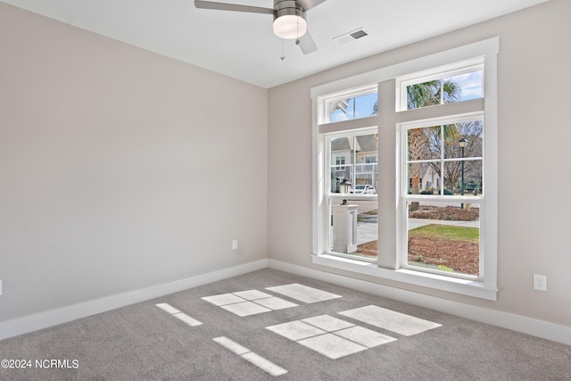 spare room with ceiling fan and light carpet