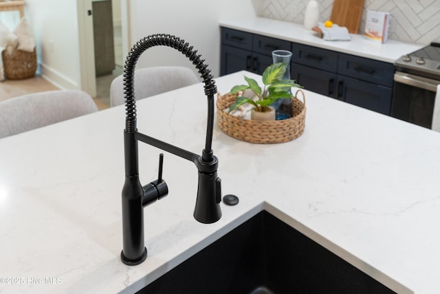 interior details featuring stainless steel range with electric stovetop, sink, and decorative backsplash