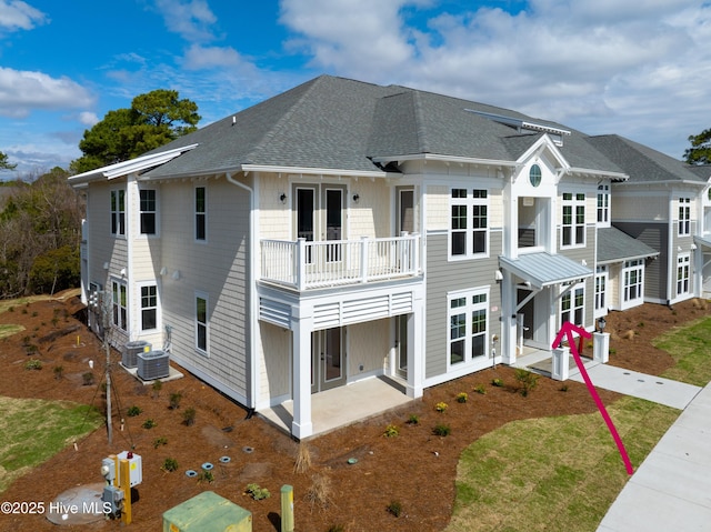 exterior space with a balcony, a patio area, central air condition unit, and french doors