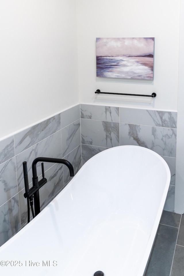 bathroom with tile patterned floors and a tub