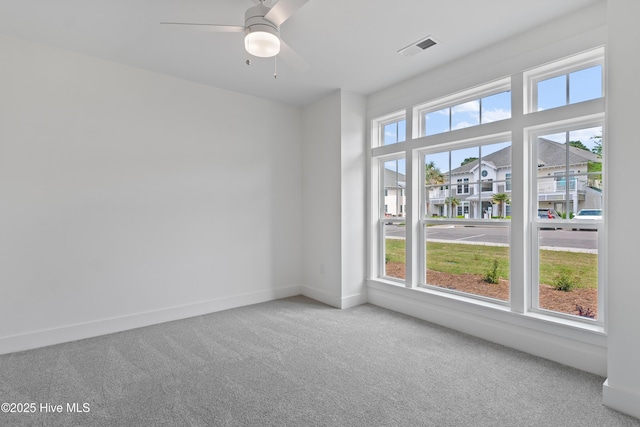 spare room featuring ceiling fan, plenty of natural light, and carpet flooring