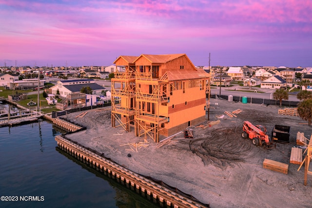 back house at dusk with a water view