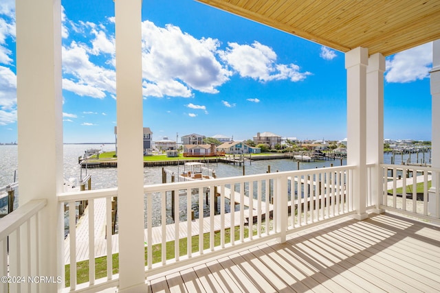 wooden terrace with a water view and a boat dock