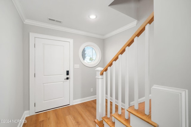 entrance foyer with crown molding and light hardwood / wood-style flooring