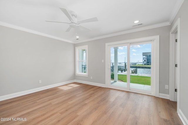 unfurnished room featuring ceiling fan, crown molding, a water view, and light wood-type flooring