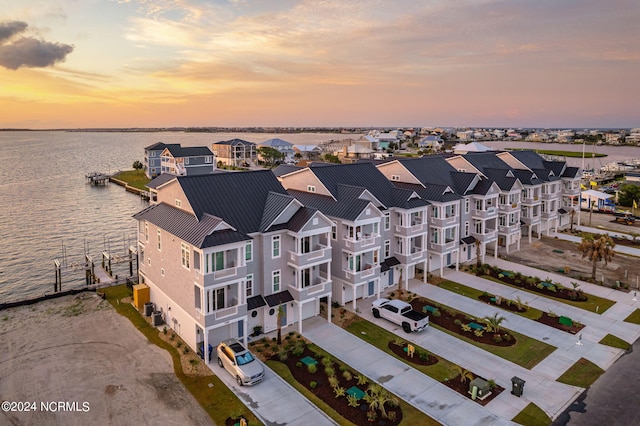 aerial view at dusk featuring a water view