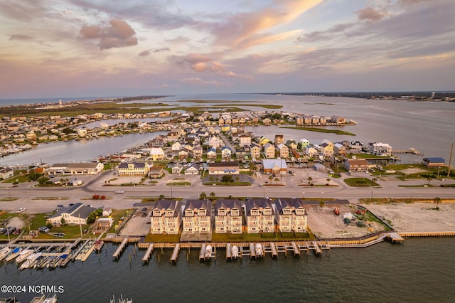 aerial view at dusk featuring a water view