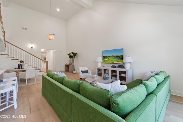 living room featuring beamed ceiling, hardwood / wood-style floors, and high vaulted ceiling